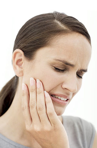 Woman wincing and holding her jaw in pain