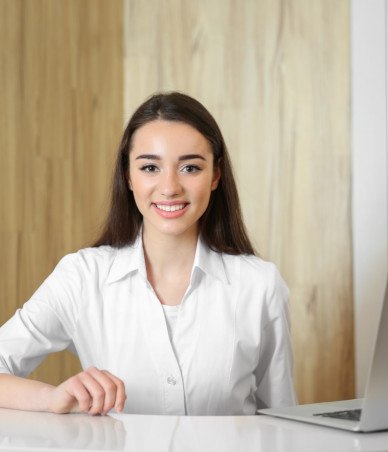 Friendly orthodontic team member behind desk