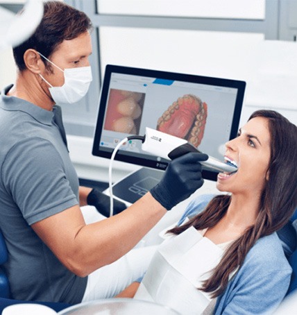 orthodontist gesturing to computer monitor with digital models of teeth