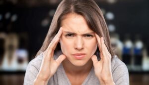 Portrait of frowning woman touching her face